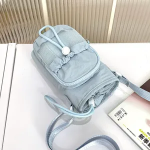 Primer plano detallado de un bolso bandolera de nailon azul claro con bolsillo de red