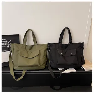 Detailed view of olive green and black large capacity tote bags on a minimalist display.