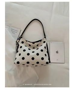 Bolso tote de lona con lunares minimalista junto a un iPad para referencia de tamaño