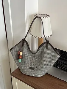 Hand-woven straw tote bag with decorative wooden beads for summer beach holidays