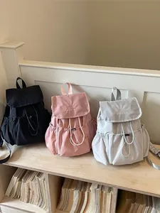 Stylish pleated drawstring backpacks in black, pink, and gray for travel and school.
