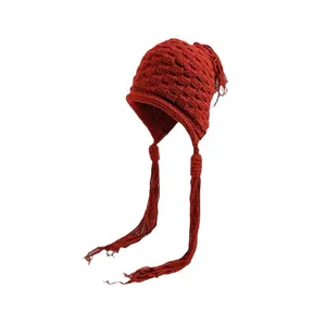 Handgefertigte rote Strickmütze mit langen Quasten und Ohrenklappen für den Winter.