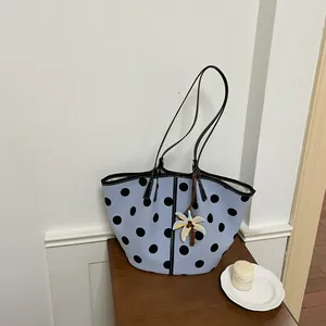 Stylish light blue polka dot tote bag featuring a palm tree pendant on a wooden surface