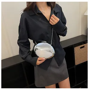 Elegante borsa da sera a specchio argento con tracolla a catena indossata da una modella