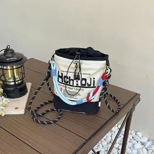 Nahaufnahme einer Leinwand-Beuteltasche mit bunten Seilriemen auf einem Tisch im Freien.