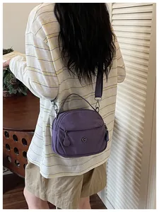 Bolso bandolera de nailon morado con correa ajustable y bolsillo delantero con cremallera