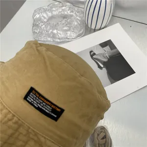 Detailopname van een retro katoenen vissershoed met zwart geweven label.