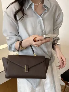 Elegant dark brown leather handbag with gold metal clasp for modern office women