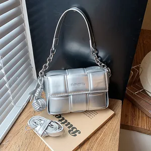 Metallic silver woven shoulder bag with chain strap and decorative knot charm detail