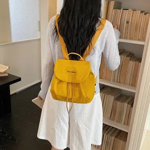 Gros plan d'un sac à dos jaune léger de style coréen porté par une fille dans une bibliothèque