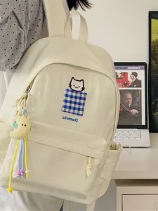 Minimalist Japanese style cream backpack featuring cute cat embroidery and moon plush charm