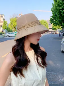 Side view of an elegant beige breathable sun hat for women worn on a sunny street