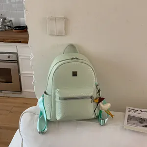Uno zaino alla moda verde menta intrecciato visualizzato in un ambiente domestico