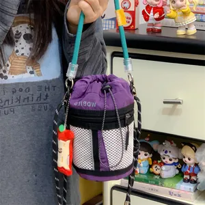 Purple nylon drawstring bucket bag with white mesh detail and cute apple charm pendant.