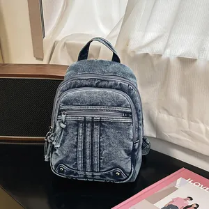 Detailed view of a trendy washed denim backpack with multi-zipper compartments