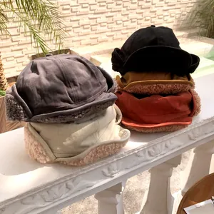 Macro detail of plush fleece earflap hats in various warm colors for winter warmth.