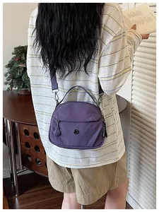 Vista trasera de un bolso bandolera de tela morada informal llevado por una persona