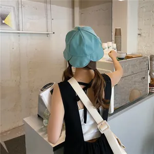 Back view of a woman wearing a blue lotus leaf edge bucket hat in a cafe setting