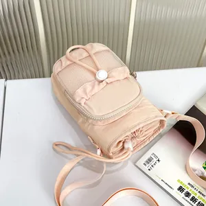 Vista detallada del bolso bandolera rosa claro para móvil con diseño de malla
