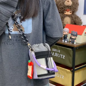 Detailed shot of the minimalist grey grid bucket bag featuring purple rope handle