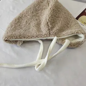 Detail of warm sherpa earflap hat showing soft fleece lining and texture
