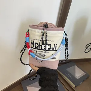 Nahaufnahme einer modischen Canvas-Beuteltasche mit bunten Seilen und markantem Buchstabendruck.