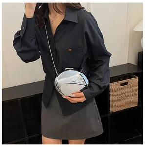 Modella chic che indossa una borsa da sera a specchio argento con catena sottile