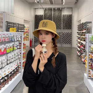 Lifestyle view of stylish yellow bucket hat with bunny ears worn by model in market