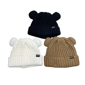 Tre simpatici berretti in maglia con orecchie da orso in nero panna e marrone inverno.