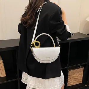 Detail einer stylischen silbernen Satteltasche mit goldenem Ring als Umhängetasche