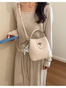 Sac seau vintage blanc crème élégant avec breloque étoile porté par un mannequin en détail
