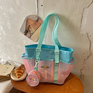 Lifestyle detail of a large mesh tote bag featuring a pink and blue contrast with matching pouch.