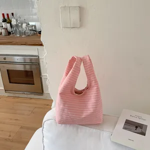 Rosa karierte Stoff-Beuteltasche für Damen mit Herzfutter in einer gemütlichen Innenumgebung.