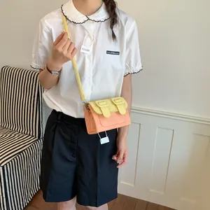 Stylish lifestyle shot of a color-block mini crossbody bag in bright yellow and pink tones