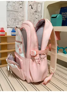 Side view of pink school backpack with star charms and multiple compartments