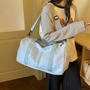 Modelo llevando un bolso de viaje azul claro de gran capacidad con motivo de estrellas