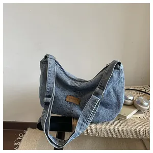 Λεπτομέρεια casual πλυμένης τσάντας τζιν με ρυθμιζόμενο λουρί σε έναν μινιμαλιστικό πάγκο