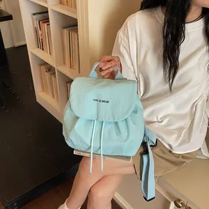 Vue détaillée d'un sac à dos léger en nylon bleu clair dans un cadre intérieur chaleureux