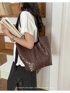 Elegant vintage brown woven leather tote bag for women being carried by a model