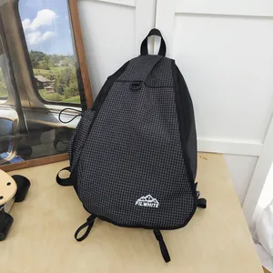 Dettaglio di una borsa a tracolla da trekking nera a griglia con il logo FILWHITE montano