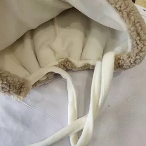 Close-up detail showing the warm white fleece lining and soft sherpa texture on a winter hat
