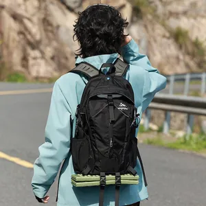 Rückansicht eines schwarzen Wanderrucksacks mit befestigter grüner Isomatte