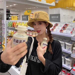 Stylish mustard yellow bucket hat with cute rabbit ear embroidery worn by model in store