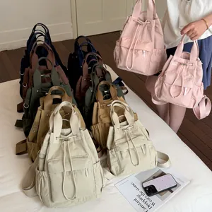 Colección de mochilas de colores con cordón en un entorno minimalista