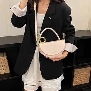 Detailansicht einer rosa Satteltasche für Damen mit goldenem Griff und Schultergurt