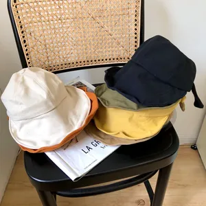 Selección de varios sombreros de pescador de ala ancha coloridos para mujer en una silla