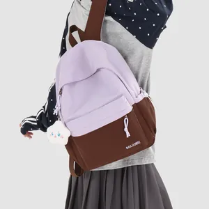 Detail of a lavender and brown color-blocked academic style backpack with a cloud charm