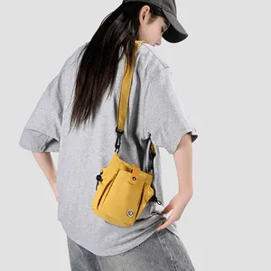 Mini sac à bandoulière jaune pour téléphone porté par un mannequin en style décontracté