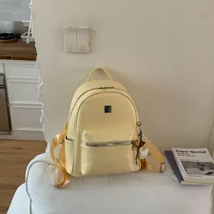 Zaino intrecciato giallo pallido stile college vintage su un divano bianco minimalista dettaglio