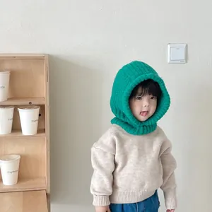 Detailed view of child wearing vibrant green knitted balaclava for winter warmth